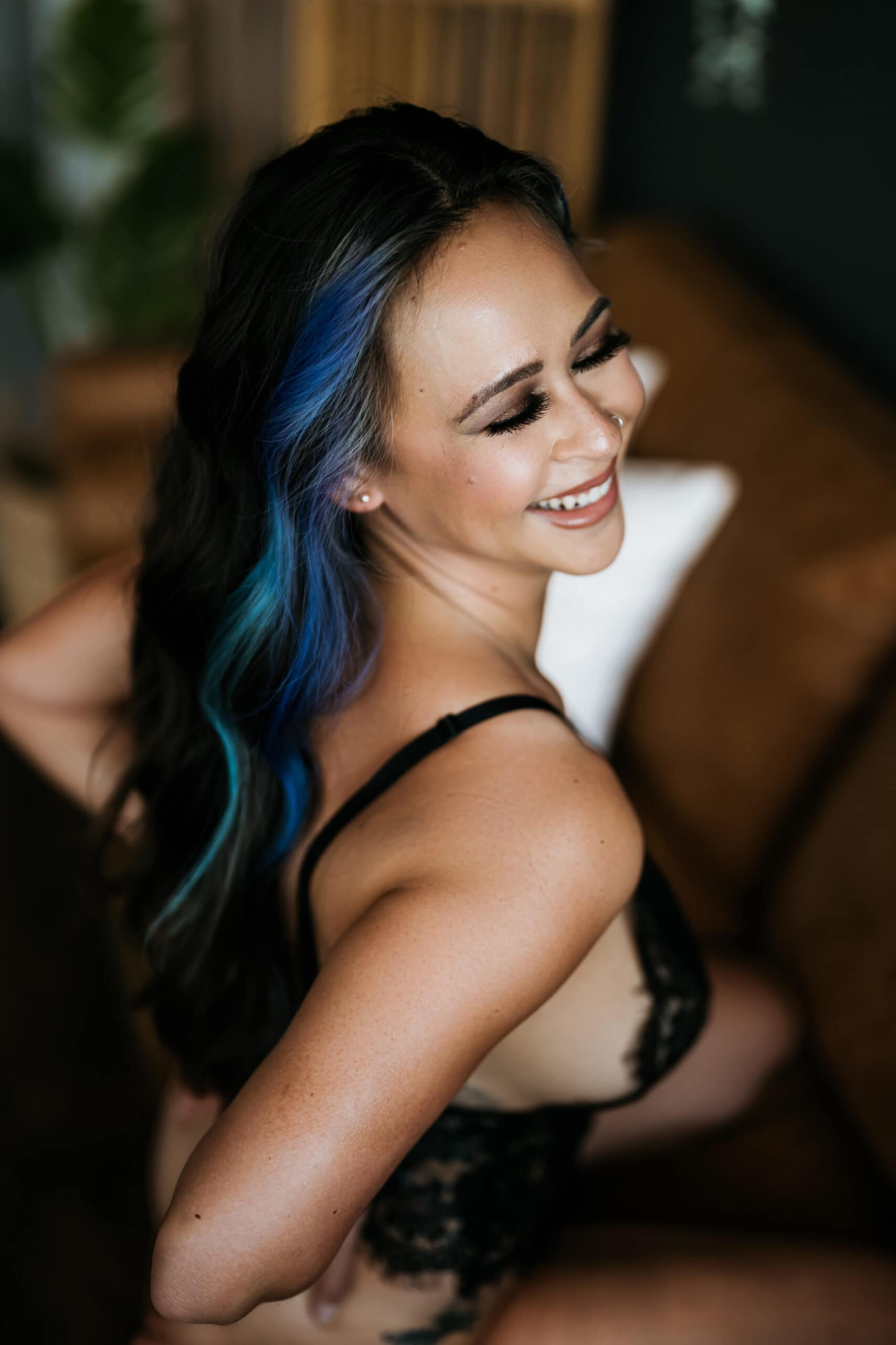 Woman smiling with blue hair streak and hands on waist. Picture by Katie O'Docharty, Denver Boudoir Photographer