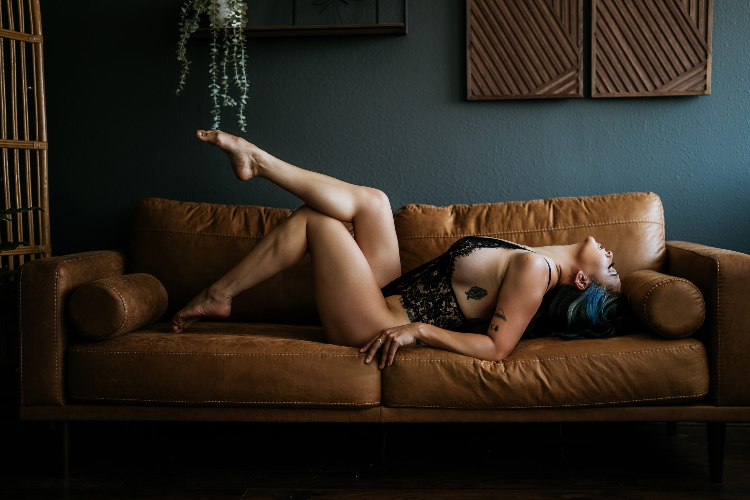Lesbian woman lying on back on couch with leg and foot extended. Photo by Katie O'Docharty, Denver Boudoir Photographer
