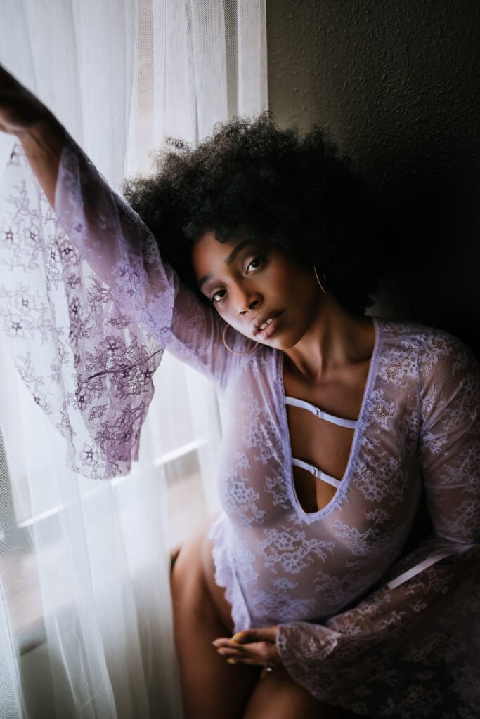 Boudoir photographer shoots beautiful black woman in purple bodysuit